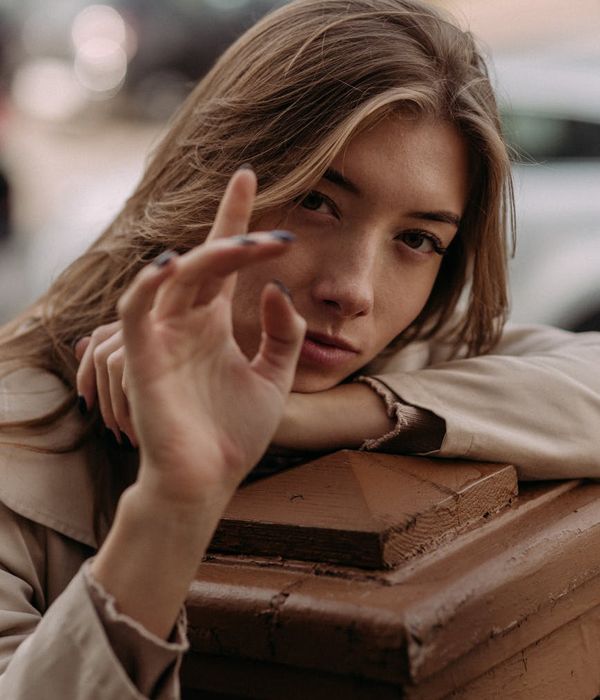 Жінка зі спокійним виразом обличчя, яка фокусується в мінімалістичному середовищі.